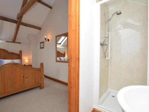 un bagno con doccia, lavandino e letto di 2 bed in Bude CORYW a Morwenstow