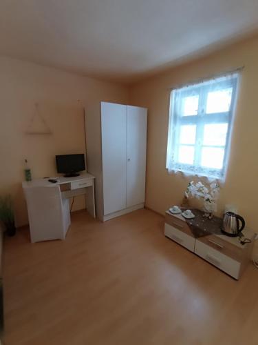 an empty living room with a computer and a desk at Penzion Jáchymov Pod Lanovkou in Jáchymov