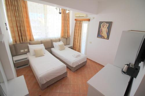 a small room with two beds and a window at Oskar Hotel in Sarandë