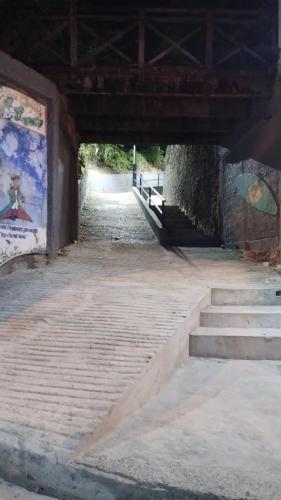 un túnel con escaleras y una pintura en la pared en Apartamentos Quintal en Morro de São Paulo