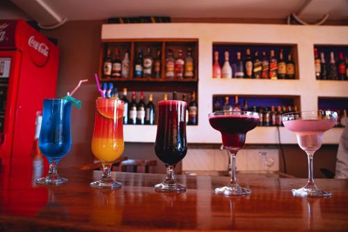 a group of four cocktails sitting on a bar at GOLDEN QUEST HOTEL in Entebbe