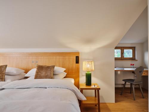 1 dormitorio con 1 cama y 1 mesa con lámpara en Bachmair Weissach See-Apartments en Rottach-Egern