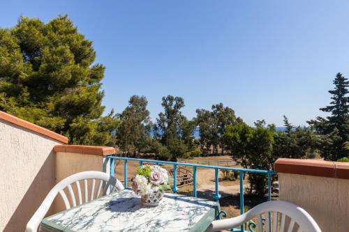 a table with a vase of flowers on a balcony at Hotel Pedra Niedda in Budoni