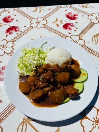 a plate of food with rice and vegetables on a table at MONKHSUURI GUESTHOUSE in Harhorin