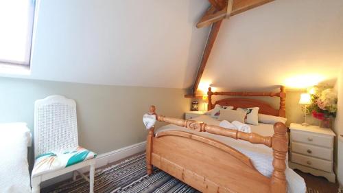 1 dormitorio con cama de madera y silla en The Loft at York House, en Birmingham
