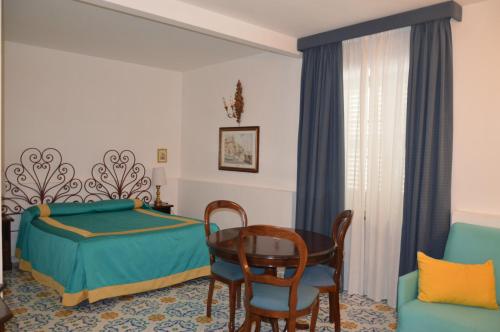 um quarto com uma cama, uma mesa e cadeiras em SEI A CAPRI em Capri