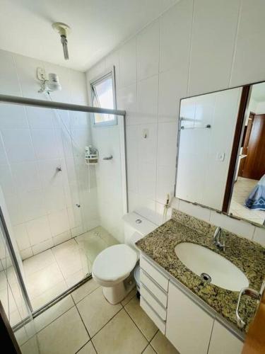 een badkamer met een toilet, een wastafel en een douche bij 2 Quartos Frente Mar em Itapuã in Vila Velha