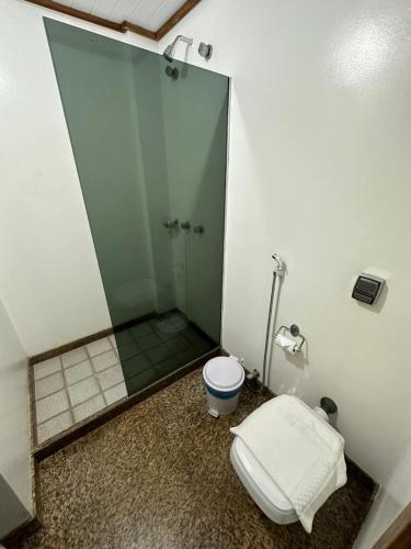 a bathroom with a toilet and a glass shower at Hotel Sol da Praia in Vitória
