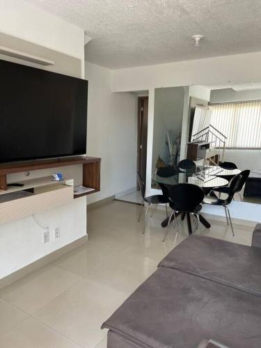 a living room with a flat screen tv and a table at Casa de 2 quartos toda mobiliada in Brasilia