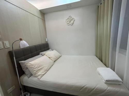 Amaze Staycation Makati في مانيلا: سرير صغير في غرفة صغيرة