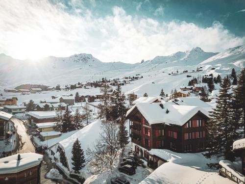 una città ricoperta di neve con montagne sullo sfondo di Hotel Garni Sonnenhalde a Arosa