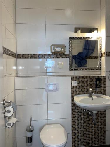 La salle de bains est pourvue de toilettes et d'un lavabo. dans l'établissement TRUST Hotel & Apartment, à Stuttgart