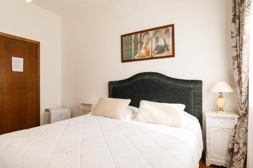a bedroom with a large white bed with two pillows at Agriturismo Villa Godenano - Pool&Restaurant in Castellina in Chianti