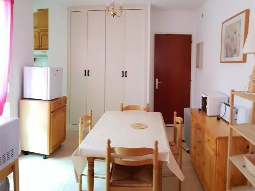 une cuisine avec une table et un réfrigérateur dans l'établissement Appartement T2 à 200m de la plage avec terrasse, parking, 5 couchages - Argelès-sur-Mer - FR-1-388-126, à Argelès-sur-Mer