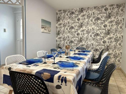 une table avec des serviettes et des chaises bleues dans une pièce dans l'établissement Maison 4 pièces, 8 couchages, proche plage et centre-ville, avec jardin et garage - FR-1-224-750, à Saint-Gilles-Croix-de-Vie