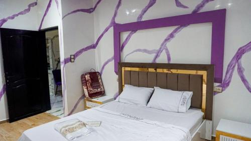 a bedroom with a bed with purple paint on the wall at العيون شارع 24 نوفمبر قرب قروان in Laayoune