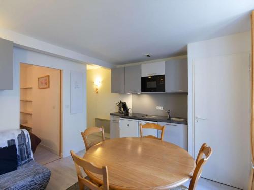 une cuisine et une salle à manger avec une table et des chaises en bois dans l'établissement Studio au cœur de Cauterets, 4 pers, 2 coins nuit, cuisine équipée, proche commodités et télécabine - FR-1-401-149, à Cauterets