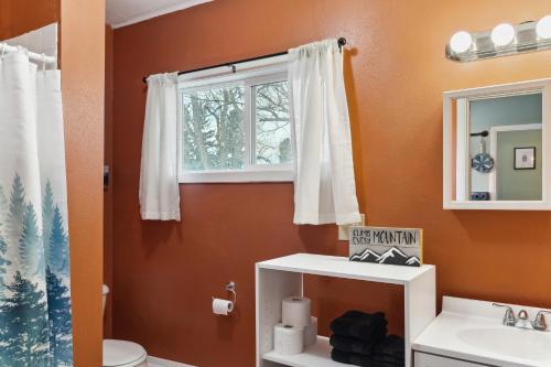 a bathroom with a toilet and a window at Choteau Vacation Rental with Yard Walk to Downtown! in Choteau