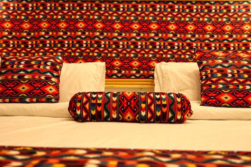 a bed with three pillows on it in a room at Oak Residency in Gilgit