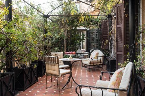 a patio with chairs and a table and books at Grand Hotel Plaza in Rome