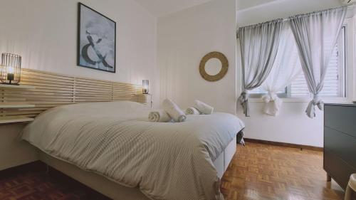 1 dormitorio blanco con 1 cama grande y 2 ventanas en STAY Antique Apartment en Lárnaca