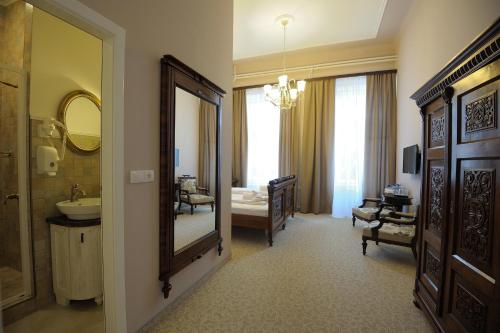 a bathroom with a sink and a mirror and a bedroom at Bed & Breakfast Twenty in Kikinda