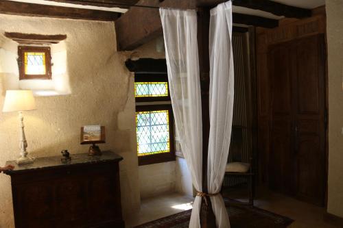 Cette chambre comprend un rideau, une table et une fenêtre. dans l'établissement La Gilbertie, à Allemans