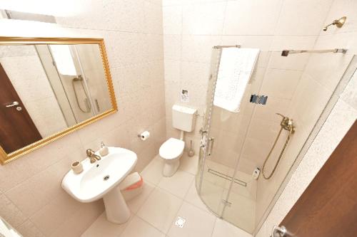 y baño con ducha, lavabo y aseo. en Hotel Restaurant Casa Cu Tei Craiova en Craiova