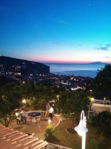 a view of a city at night with a table and lights at Garden on the Sea in Vico Equense