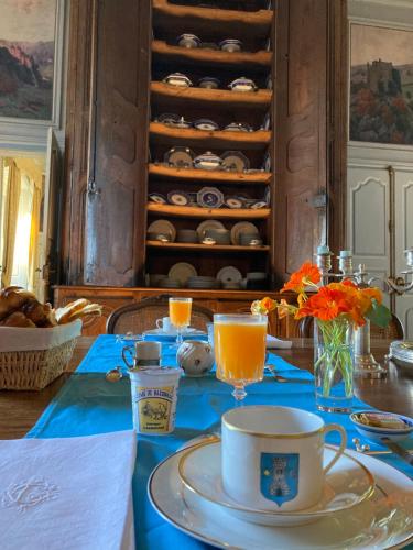 une table avec un chiffon de table bleu avec une tasse et une plaque dans l'établissement Château de La Vigne, à Ally