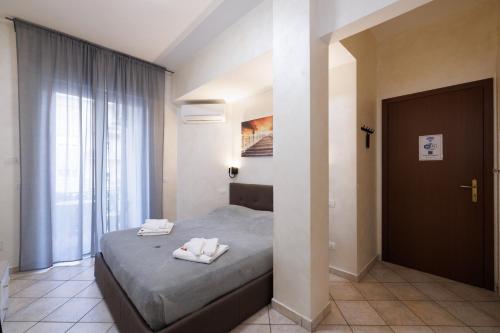 a bedroom with a bed with two towels on it at Roma Marine House in Lido di Ostia