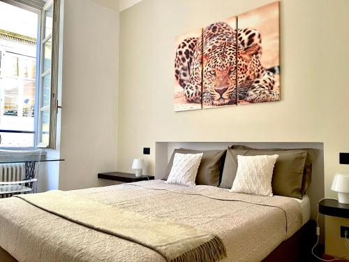 a bedroom with a bed with two paintings on the wall at CHARMING COMO - Apartment downtown in the pedestrian area with 2 double bedrooms and 2 complete bathrooms a spacious living room and full equipped kitchen in Como