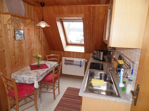 uma pequena cozinha com uma mesa e um lavatório em Zum Hecht, FeWo Spitzberg em Herrnhut