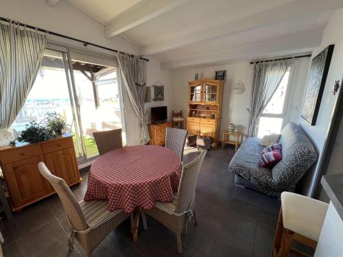 un salon avec une table et un canapé dans l'établissement T2 cabine avec terrasse, parking et animaux acceptés à 100m de la plage - FR-1-702-38, au Cap d'Agde
