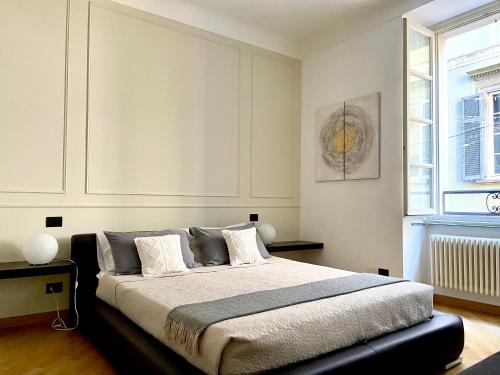 ein Schlafzimmer mit einem Bett und einem Fenster in der Unterkunft CHARMING COMO - Apartment downtown in the pedestrian area with 2 double bedrooms and 2 complete bathrooms a spacious living room and full equipped kitchen in Como