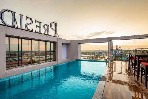 a swimming pool on the roof of a building at PRESIDENCY AIRPORT HOTEL in Cochin