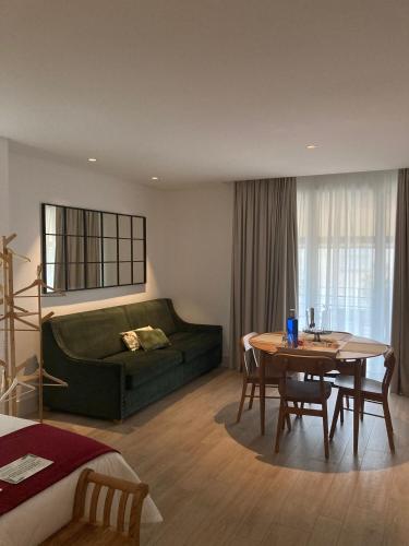 a living room with a green couch and a table at Apartamentos Turísticos La Plaza in Chipiona