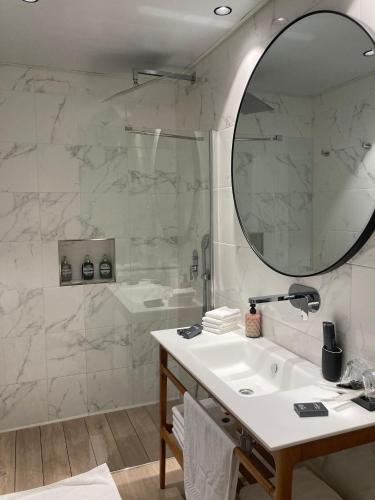 a bathroom with a sink and a mirror at Apartamentos Turísticos La Plaza in Chipiona