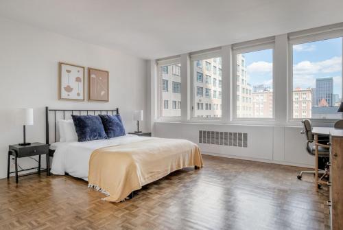 a bedroom with a bed with blue pillows and windows at Back Bay 1br w gym rooftop nr shopping BOS-926 in Boston