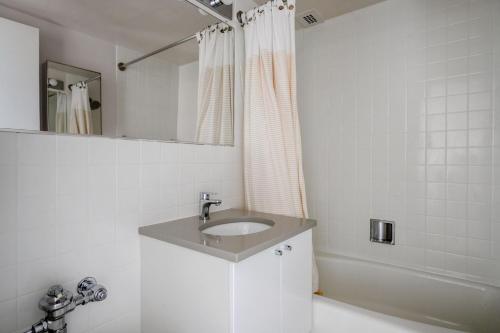 biała łazienka z umywalką i prysznicem w obiekcie Back Bay 1br w gym rooftop nr shopping BOS-926 w mieście Boston