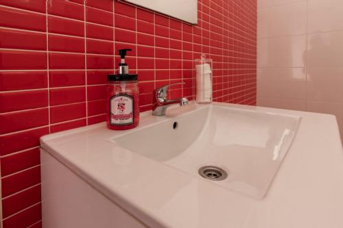 a white sink in a red tiled bathroom at Kings House in Almería