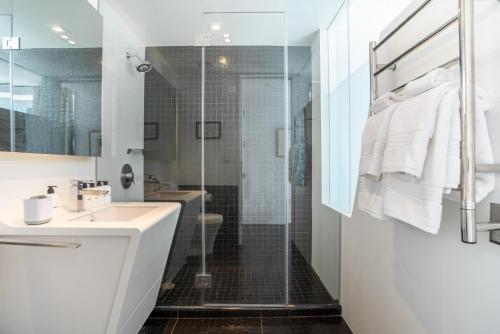 La salle de bains est pourvue d'un lavabo et d'une douche en verre. dans l'établissement Financial District 1br w WD gym elevator NYC-1362, à New York