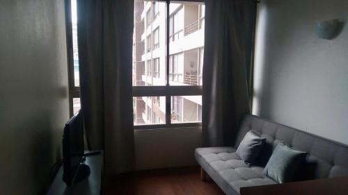 a living room with a couch in front of a window at Departamento Central Santiago in Santiago