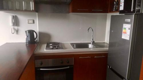a small kitchen with a sink and a stove at Departamento Central Santiago in Santiago