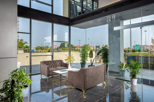 una hall con divano, sedie e piante di PRESIDENCY AIRPORT HOTEL a Cochin