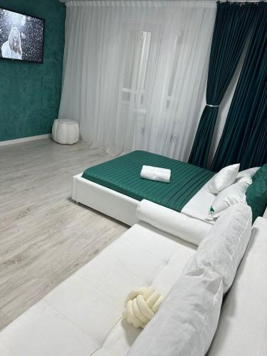 a bedroom with two beds and a tv on the wall at Апартаменты в ЖК Каркын in Kostanay