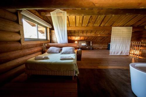 a bedroom with a bed in a log cabin at Casa Laricciu in Figari