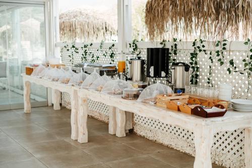 a kitchen with a long table with food on it at Aspro Phos Santorini Hotel in Perissa