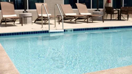 una grande piscina con sedie e tavoli di Hyatt Place Tampa/Wesley Chapel a Lutz