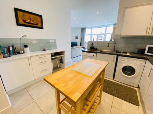 a kitchen with a table and a washing machine at Portland View - Spacious & Comfortable in Weston